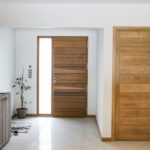 Entrée avec portes en bois, incluant les volets Guignard.