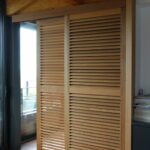 Volets Guignard en bois avec lamelles horizontales décoratives.