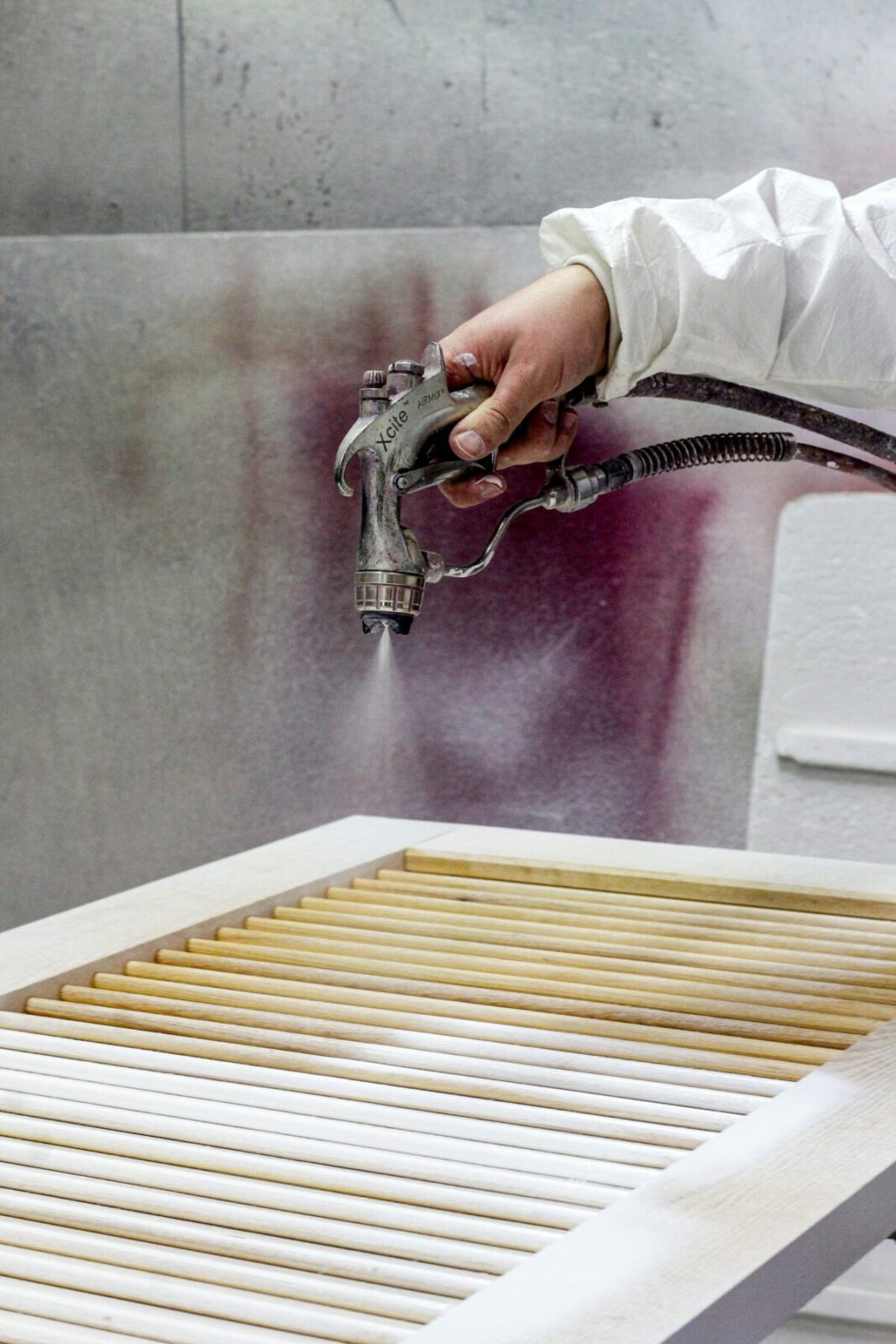 Application de peinture sur des volets Guignard en cours.