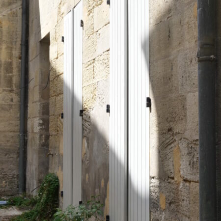 Volets blancs sur mur de pierre